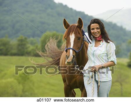 Portrait of a woman standing with a horse View Large Photo Image Stock Photo - Portrait of a woman standing with a horse. Fotosearch