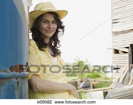 Stock Image - Portrait of a woman wearing a straw hat. Fotosearch