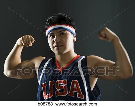Stock Photo - Portrait of a young man flexing his biceps. Fotosearch