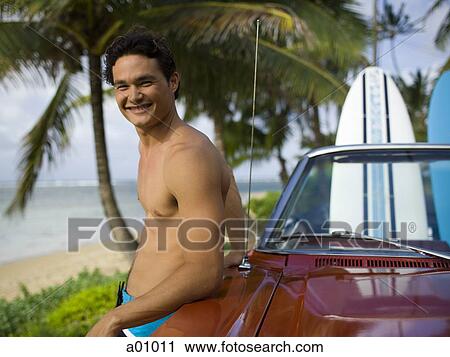 Portrait of a young man leaning against a car View Large Photo Image Stock Image - Portrait of a young man leaning against a car. Fotosearch