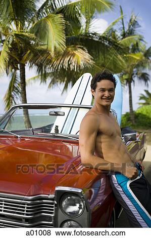 Portrait of a young man leaning against a car and smiling View Large Photo Image Stock Photo - Portrait of a young man leaning against a car and smiling. Fotosearch