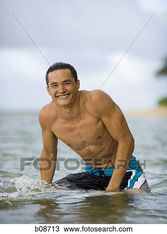 Portrait of a young man sitting on a surfboard View Large Photo Image Stock Image - Portrait of a young man sitting on a surfboard. Fotosearch
