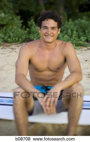 Portrait of a young man sitting on a surfboard and smiling View Large Photo Image Stock Photo - Portrait of a young man sitting on a surfboard and smiling. Fotosearch
