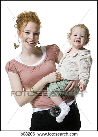 Stock Photograph - Portrait of a young woman carrying her baby girl. Fotosearch
