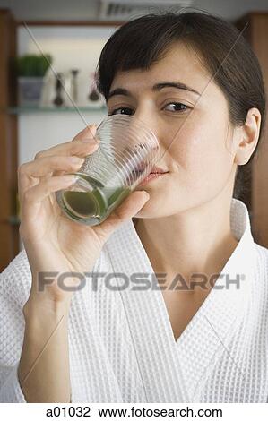 Portrait of a young woman drinking wheatgrass juice View Large Photo Image Stock Image - Portrait of a young woman drinking wheatgrass juice. Fotosearch