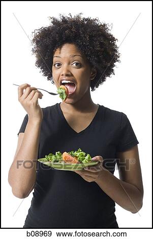 Portrait of a young woman eating salad View Large Photo Image Stock Photo - Portrait of a young woman eating salad. Fotosearch