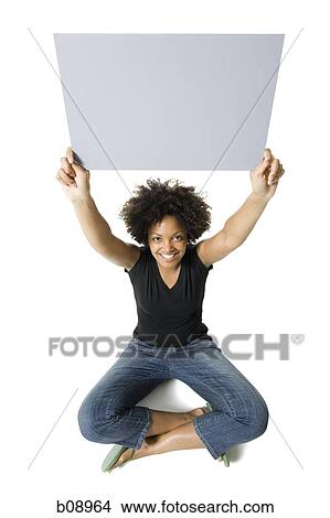 Portrait of a young woman holding a blank sign View Large Photo Image Picture - Portrait of a young woman holding a blank sign. Fotosearch