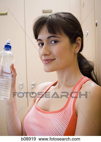 Portrait of a young woman holding a water bottle View Large Photo Image Stock Photo - Portrait of a young woman holding a water bottle. Fotosearch