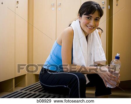 Portrait of a young woman holding a water bottle and smiling View Large Photo Image Stock Photo - Portrait of a young woman holding a water bottle and smiling. Fotosearch
