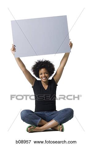 Portrait of a young woman holding a blank sign View Large Photo Image Stock Photo - Portrait of a young woman holding a blank sign. Fotosearch