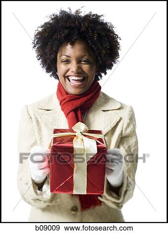 Portrait of a young woman holding a gift box View Large Photo Image Stock Photo - Portrait of a young woman holding a gift box. Fotosearch