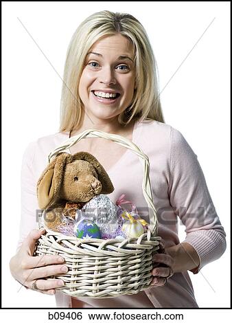 Stock Photograph - Portrait of a young woman holding a teddy bear in a wicker basket. Fotosearch