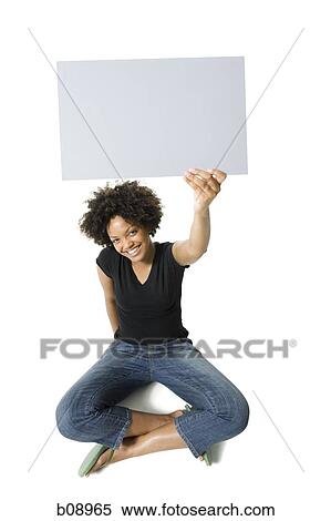 Stock Photography - Portrait of a young woman holding a blank sign. Fotosearch