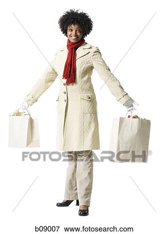 Portrait of a young woman holding shopping bags View Large Photo Image Stock Photo - Portrait of a young woman holding shopping bags. Fotosearch