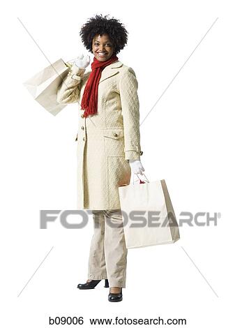 Portrait of a young woman holding shopping bags View Large Photo Image Stock Photograph - Portrait of a young woman holding shopping bags. Fotosearch