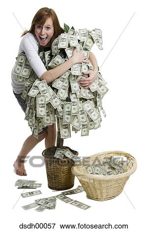 Stock Photo - Portrait of a young woman hugging a money tree. Fotosearch