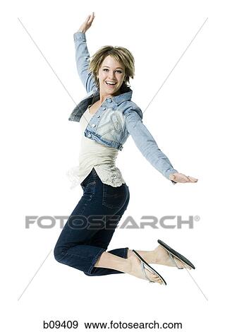 Portrait of a young woman jumping in mid air View Large Photo Image Stock Photo - Portrait of a young woman jumping in mid air. Fotosearch