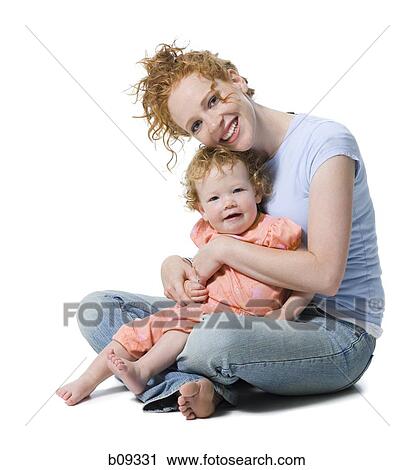 Portrait of a young woman sitting with her daughter View Large Photo Image Stock Image - Portrait of a young woman sitting with her daughter. Fotosearch