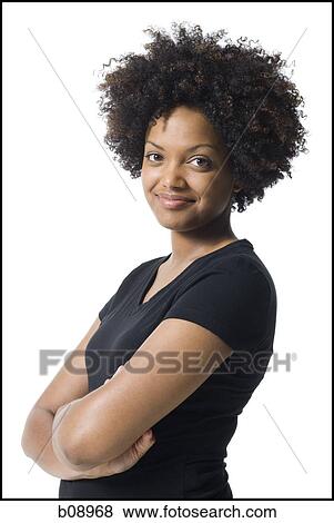 Portrait of a young woman smiling with her arms crossed View Large Photo Image Stock Photo - Portrait of a young woman smiling with her arms crossed. Fotosearch