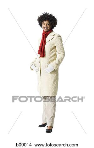 Portrait of a young woman standing with her hands in her pockets View Large Photo Image Picture - Portrait of a young woman standing with her hands in her pockets. Fotosearch