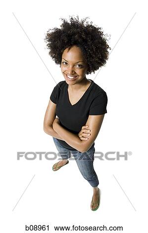 Portrait of a young woman standing with her arms crossed View Large Photo Image Stock Image - Portrait of a young woman standing with her arms crossed. Fotosearch