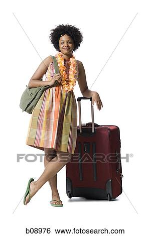 Portrait of a young woman standing with luggage View Large Photo Image Stock Photograph - Portrait of a young woman standing with luggage. Fotosearch