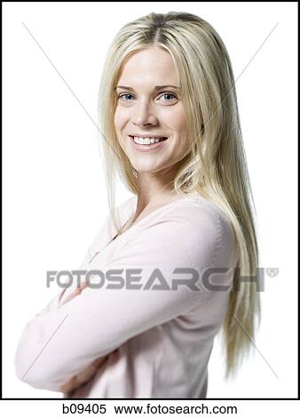 Stock Photography - Portrait of a young woman standing with her arms crossed. Fotosearch