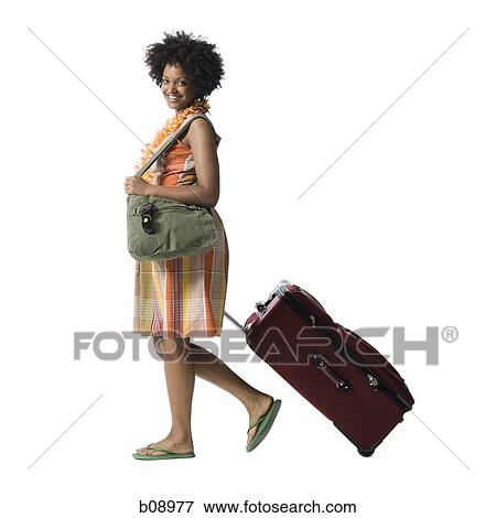 Portrait of a young woman walking with luggage View Large Photo Image Stock Photo - Portrait of a young woman walking with luggage. Fotosearch