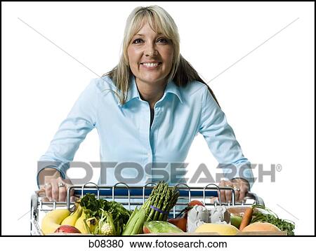 Portrait of an adult woman holding a shopping cart of vegetables and smiling View Large Photo Image Stock Image - Portrait of an adult woman holding a shopping cart of vegetables and smiling. Fotosearch