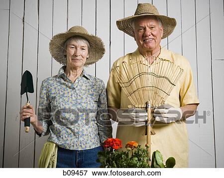 Portrait of an elderly couple standing with gardening tools View Large Photo Image Stock Photo - Portrait of an elderly couple standing with gardening tools. Fotosearch