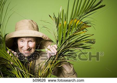 Portrait of an elderly woman smiling between palm leaves View Large Photo Image Stock Photograph - Portrait of an elderly woman smiling between palm leaves. Fotosearch