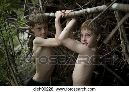 Stock Photo - Portrait of two boys holding a branch. Fotosearch