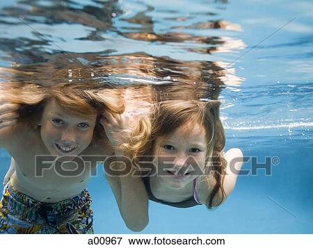 Portrait of two children swimming underwater and smiling View Large Photo Image Stock Photo - Portrait of two children swimming underwater and smiling. Fotosearch