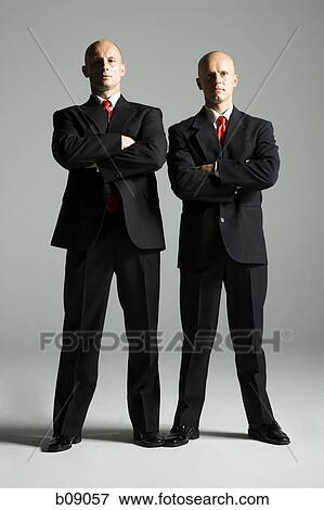 Stock Photo - Portrait of two mid adult men standing side by side. Fotosearch