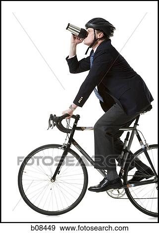 Profile of a businessman cycling and holding from a mug View Large Photo Image Stock Photo - Profile of a businessman cycling and holding from a mug. Fotosearch