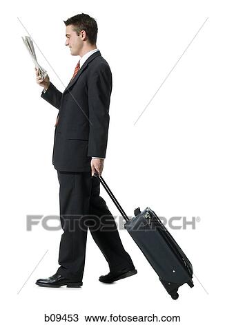 Profile of a businessman walking with luggage View Large Photo Image Stock Image - Profile of a businessman walking with luggage. Fotosearch