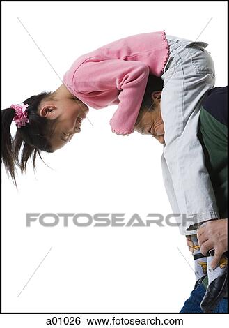 Stock Photograph - Profile of a father carrying his daughter on his shoulders. Fotosearch