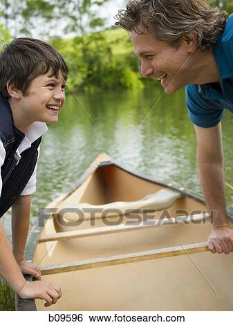Profile of a man and his son bending forward over a canoe View Large Photo Image Stock Photograph - Profile of a man and his son bending forward over a canoe. Fotosearch