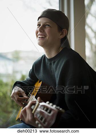 Profile of a teenage boy playing the guitar View Large Photo Image Stock Image - Profile of a teenage boy playing the guitar. Fotosearch