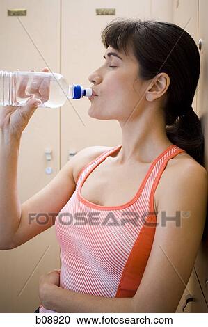 Profile of a young woman drinking water from a water bottle View Large Photo Image Stock Image - Profile of a young woman drinking water from a water bottle. Fotosearch