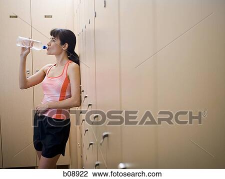 Stock Image - Profile of a young woman drinking water from a water bottle. Fotosearch