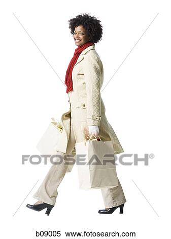 Profile of a young woman holding shopping bags View Large Photo Image Stock Photography - Profile of a young woman holding shopping bags. Fotosearch