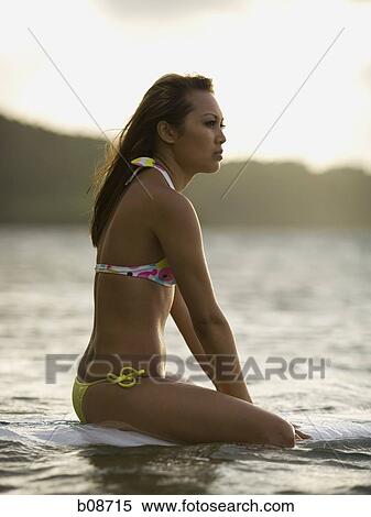 Profile of a young woman sitting on a surfboard View Large Photo Image Stock Photography - Profile of a young woman sitting on a surfboard. Fotosearch