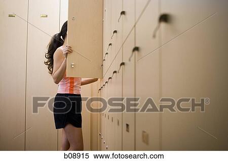 Profile of a young woman standing behind a closet door View Large Photo Image Stock Photography - Profile of a young woman standing behind a closet door. Fotosearch