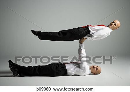 Profile of two male acrobats in business suits performing View Large Photo Image Stock Image - Profile of two male acrobats in business suits performing. Fotosearch