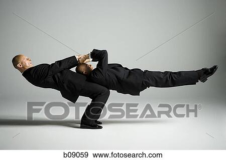 Profile of two male acrobats in business suits performing View Large Photo Image Stock Photo - Profile of two male acrobats in business suits performing. Fotosearch