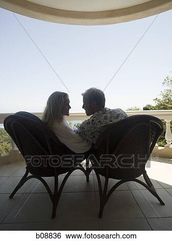 Rear view of a couple on the veranda View Large Photo Image Stock Photograph - Rear view of a couple on the veranda. Fotosearch