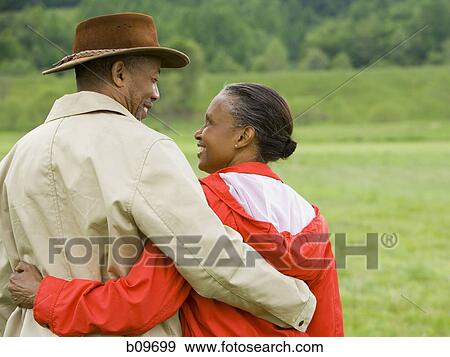 Rear view of a senior man and a senior woman with their arms around each other View Large Photo Image Stock Photo - Rear view of a senior man and a senior woman with their arms around each other. Fotosearch