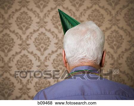 Rear view of an elderly man wearing a birthday hat View Large Photo Image Stock Photo - Rear view of an elderly man wearing a birthday hat. Fotosearch