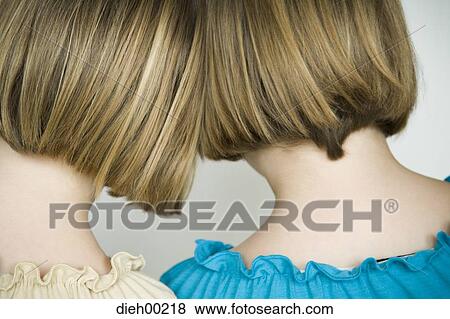 Rear view of two girls touching their heads View Large Photo Image Stock Photo - Rear view of two girls touching their heads. Fotosearch